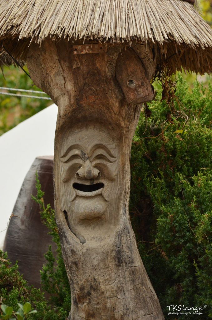 A traditional Korean mask carved in a tree (as a mailbox?)